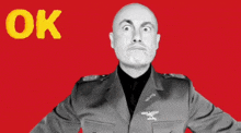 a bald man in a military uniform is making an ok sign