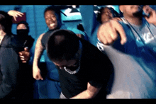 a group of people are dancing and pointing at the camera in a dark room .