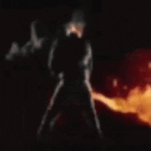a blurred image of a person in a red cape standing in front of a fire .