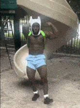 a shirtless man in a finn costume is standing in front of a slide