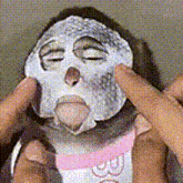 a person is applying a mask to their face .