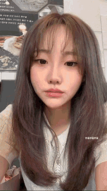 a close up of a woman 's face with a sign in the background that says ' korean ' on it