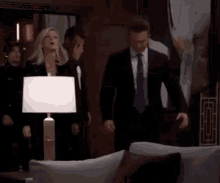 a group of people in suits are standing in a living room .