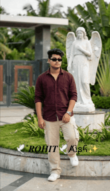 a young man stands in front of a statue of an angel with the name rohit aish on the bottom