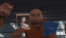 a man is holding up a picture of a baby