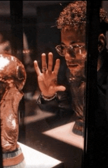 a man wearing glasses is looking at a trophy