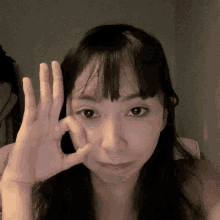 a woman is making an ok sign with her hands