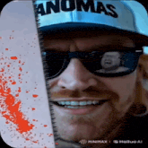 a man wearing sunglasses and a hat that says ' anomas ' on it