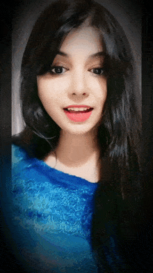 a woman with long black hair is wearing a blue lace top