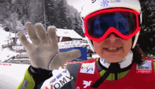 a person wearing a helmet and goggles with the word omv on their glove