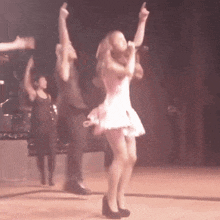 a woman in a pink dress singing into a microphone