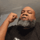 a man with a beard wearing a black shirt with a bat on it
