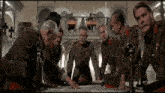 a group of men in military uniforms sit around a table