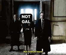 a group of people standing next to each other in a room with a sign that says not gal but room for more .