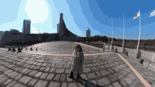 a woman stands on a brick walkway in front of a building