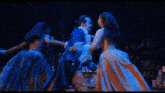 a man and a woman are dancing on a stage with blue lights