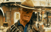 a man in a cowboy hat is holding a gun in front of a sign that says ' smith ' on it