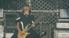a man playing a guitar with a shirt that says skv on it