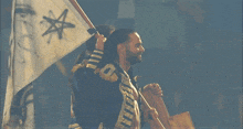 a man in a military uniform holds up a flag with a star on it