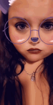 a woman wearing glasses and a lock necklace