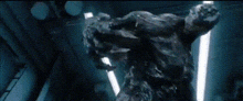 two monsters are fighting each other in a dark room with lights behind them