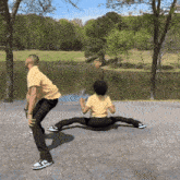 a man and a woman are doing a split in front of a body of water