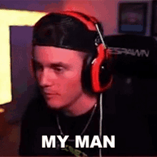 a man wearing headphones and a hat is sitting in front of a computer screen with the caption my man .