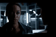 a man and a woman are standing next to each other in a dark room . the woman has a glowing face .