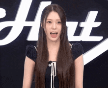 a woman stands in front of a sign that says ' hot '
