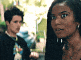 a man and a woman are standing next to each other and the woman is wearing a necklace and earrings