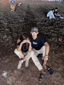 a man in a ny hat sits next to a woman