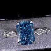 a diamond ring with a blue stone in the middle