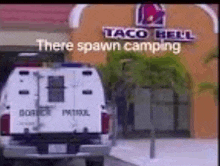 a taco bell restaurant with a spawn camping van parked in front of it .