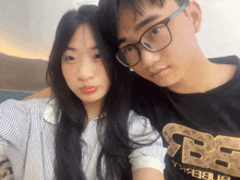 a man and a woman are posing for a picture and the man is wearing a shirt that says ' bb ' on it