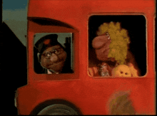 a red bus with two cartoon characters in the driver 's window
