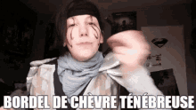 a person wearing a scarf and a headband says bordel de chevre tenebreuse