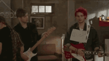 a man in a red hat is playing a guitar and holding a piece of paper that says duck .