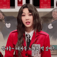a woman wearing a red jacket and tie is speaking in korean
