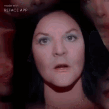 a woman is making a funny face in front of a group of people .