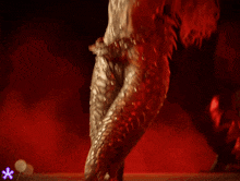 a woman with long red hair is wearing a silver and red outfit
