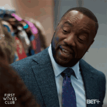 a man in a suit and tie with the words first wives club on the bottom