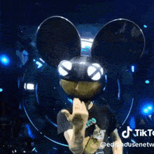 a man wearing a mickey mouse mask on a stage
