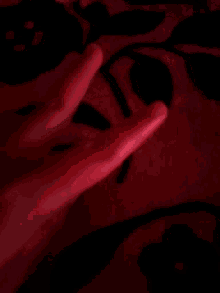 a close up of a person 's hands on a red background