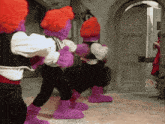 a group of purple and red stuffed animals standing in a room
