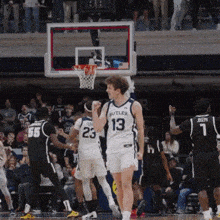 a basketball player wearing a butler jersey holds his fist in the air