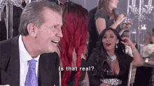 a man in a suit and tie is talking to a woman with red hair and the words is that real