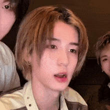 a close up of a person 's face with a group of people behind them .