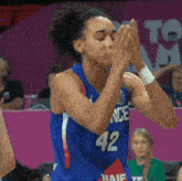 a female basketball player wearing a blue jersey with the number 42