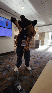 a man in a furry costume is standing in front of a tv screen that says ' iced tea ' on it