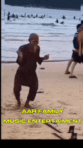 a man is dancing on a beach with the words aar family music entertainment